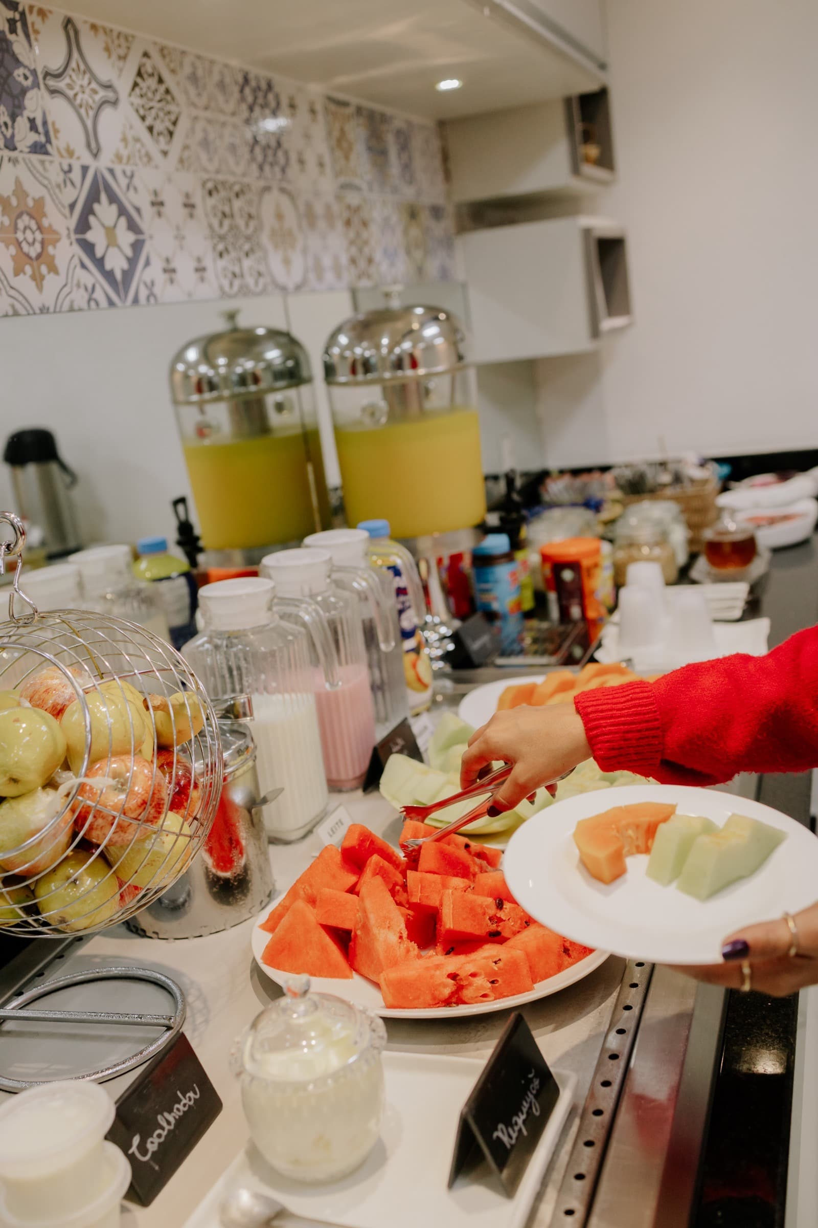 Hóspede servindo frutas frescas no buffet do café da manhã