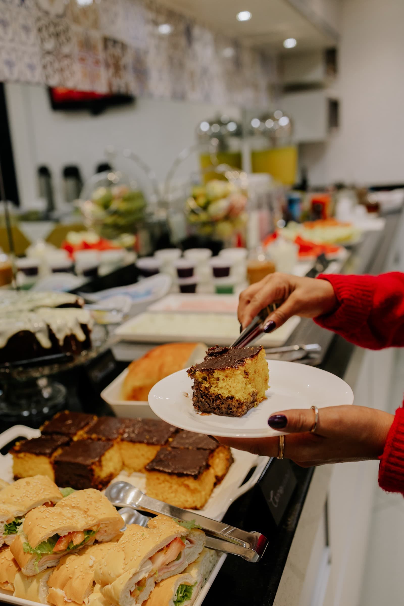 Fatia de bolo de chocolate sendo servida no café da manhã