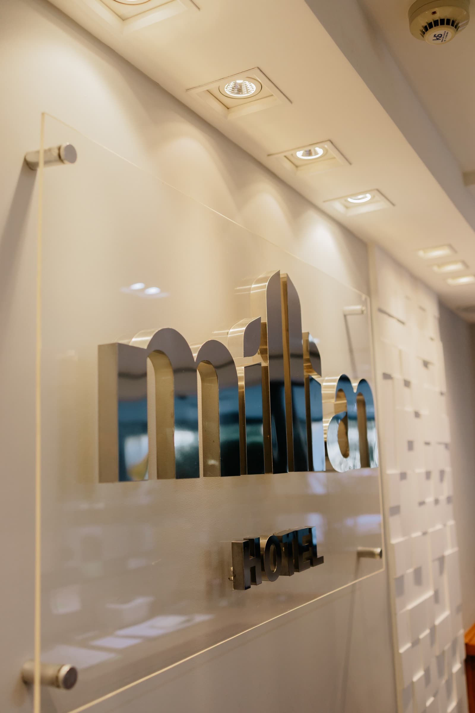 Logotipo do Millian Hotel na parede da recepção