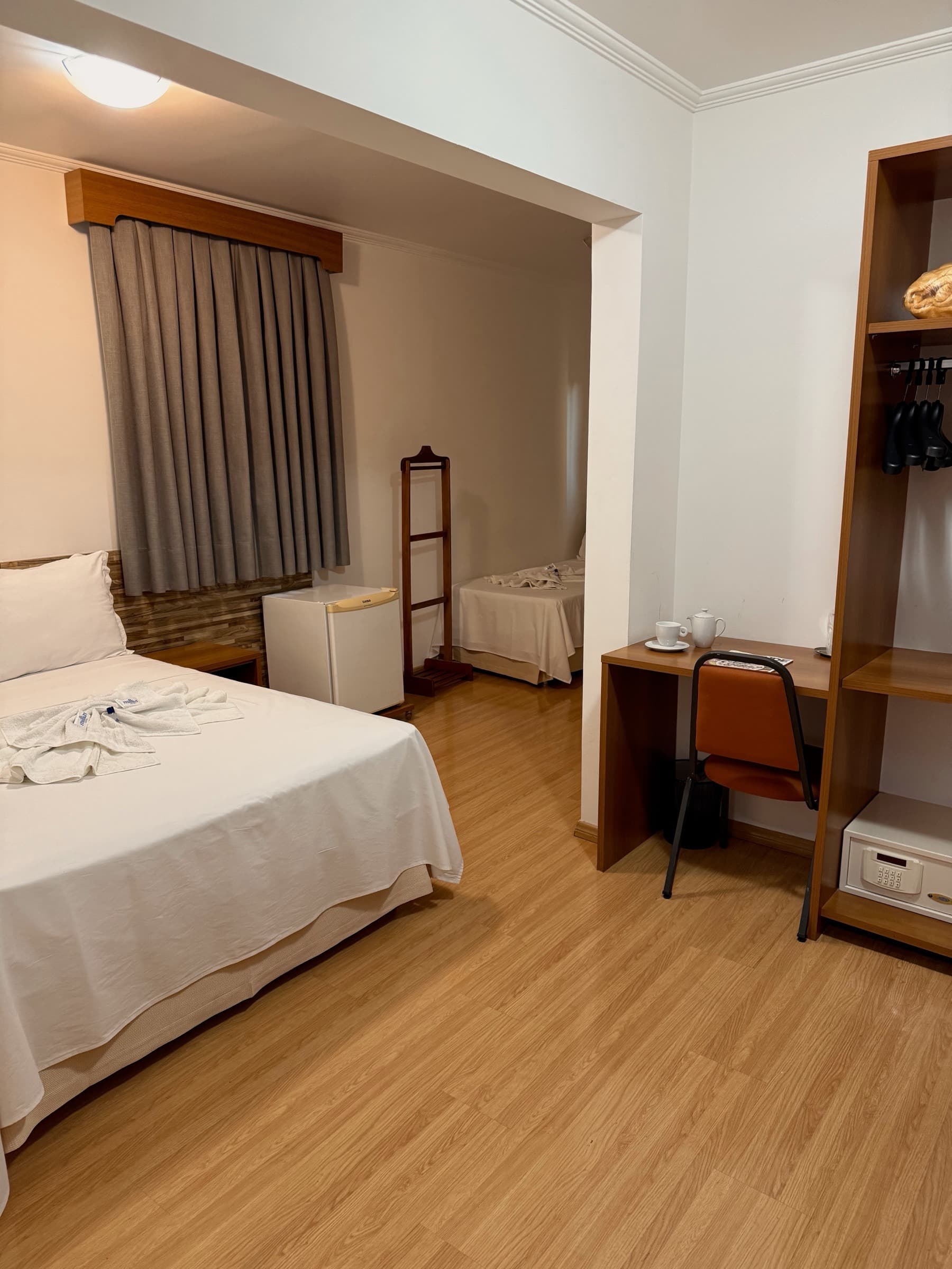 Suíte com cama de casal, closet e cama de solteiro ao fundo